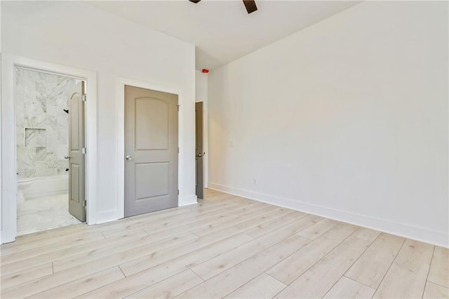 empty room featuring ceiling fan, baseboards, and light wood-style flooring