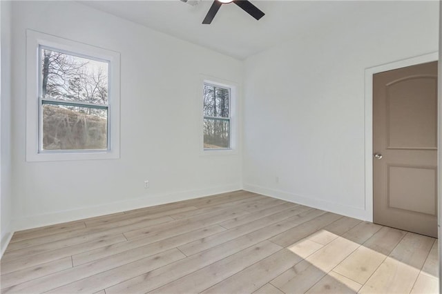 unfurnished room with baseboards, light wood-style floors, a healthy amount of sunlight, and ceiling fan