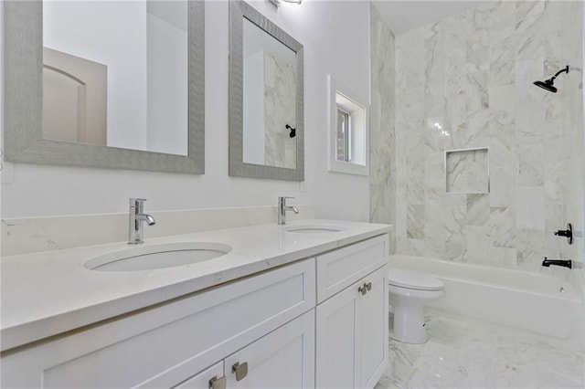 bathroom with double vanity, marble finish floor, toilet, and a sink