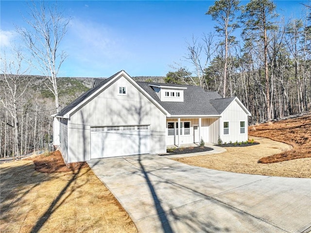 view of front facade with covered porch, driveway, an attached garage, and a front yard