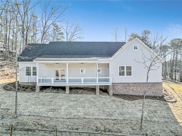 back of property featuring covered porch and roof with shingles