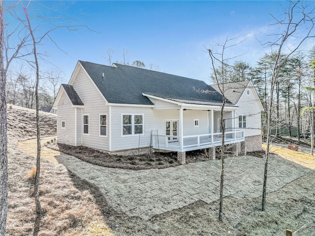 back of property with a wooden deck and a shingled roof