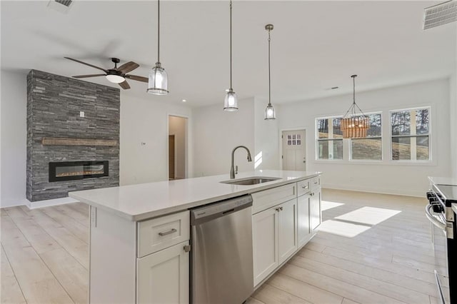 kitchen with visible vents, a sink, open floor plan, stainless steel appliances, and a large fireplace