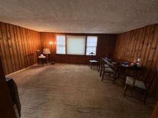 living area with wooden walls and carpet