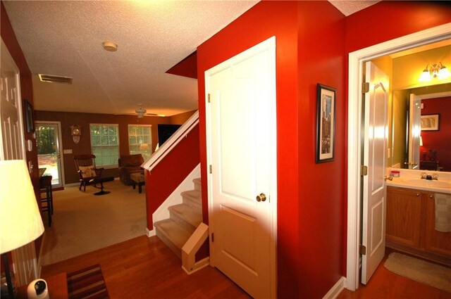 70 Darbys Crossing Ct, Hiram, GA 30141 - hall featuring a textured ceiling, stairway, baseboards, wood finished floors, and a sink