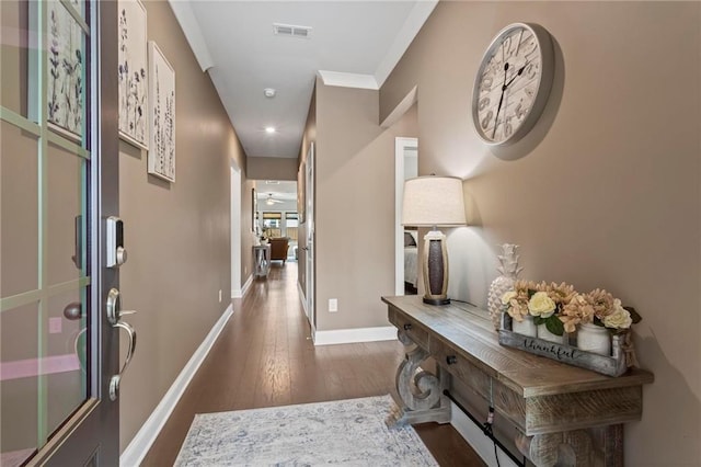 hallway with dark hardwood / wood-style flooring and ornamental molding