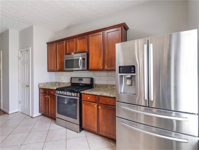 5351 Paramount View Way, Sugar Hill, GA 30518 - kitchen with stainless steel appliances, brown cabinets, light stone counters, light tile patterned floors, and a textured ceiling