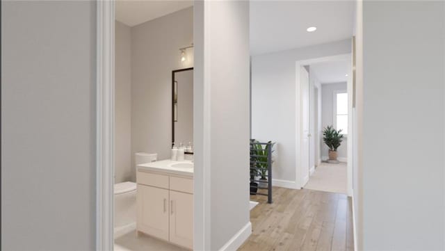 bathroom featuring vanity, hardwood / wood-style floors, and toilet