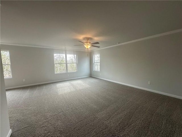 carpeted spare room with crown molding, baseboards, and ceiling fan