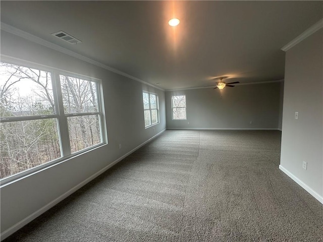 carpeted empty room with visible vents, ornamental molding, baseboards, and a ceiling fan