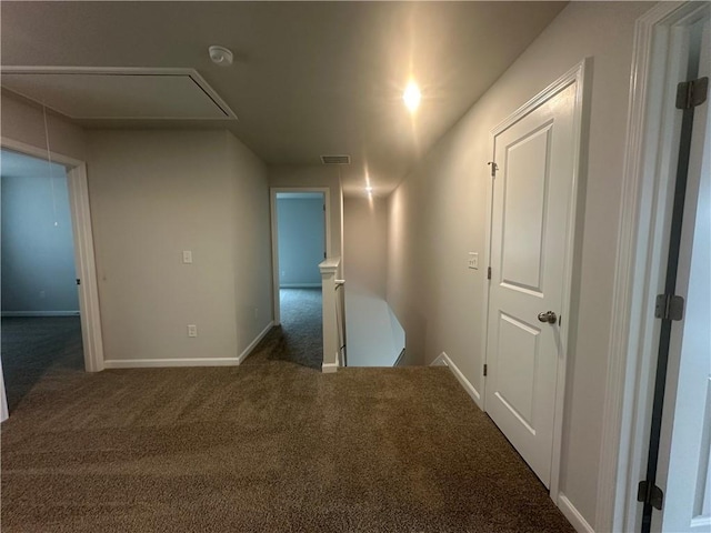 hall with carpet floors, attic access, baseboards, an upstairs landing, and visible vents