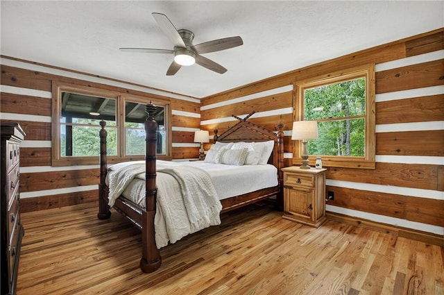 212 Dogpatch Ln, Blue Ridge, GA 30513 - bedroom featuring wooden walls, multiple windows, light wood finished floors, and a ceiling fan