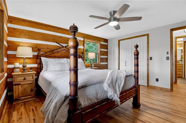 212 Dogpatch Ln, Blue Ridge, GA 30513 - bedroom featuring light wood-style floors, baseboards, a closet, wooden walls, and ceiling fan