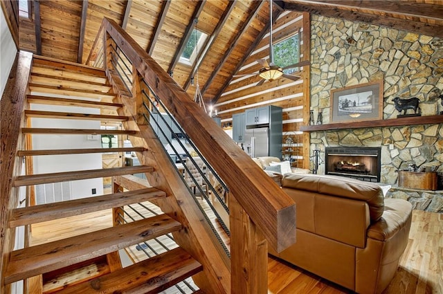 212 Dogpatch Ln, Blue Ridge, GA 30513 - staircase featuring wooden ceiling with exposed beams, wood finished floors, high vaulted ceiling, and a fireplace
