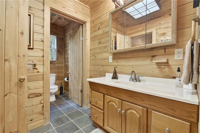 212 Dogpatch Ln, Blue Ridge, GA 30513 - bathroom featuring wood walls, toilet, vanity, a skylight, and wood ceiling