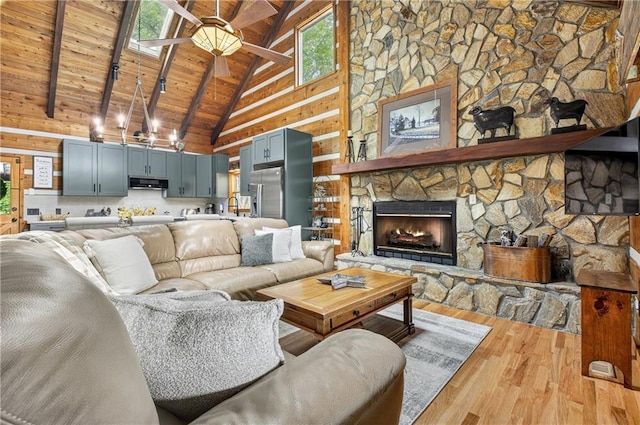 212 Dogpatch Ln, Blue Ridge, GA 30513 - living area featuring light wood finished floors, high vaulted ceiling, wood ceiling with exposed beams, healthy amount of natural light, and a fireplace