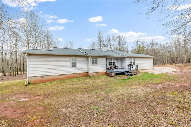 back of property featuring crawl space, a wooden deck, a chimney, and a yard