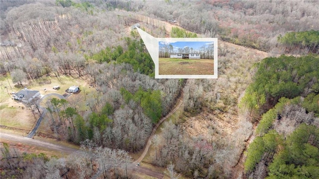 drone / aerial view with a wooded view