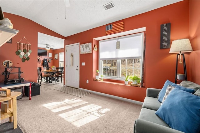 carpeted living area featuring a ceiling fan, baseboards, visible vents, lofted ceiling, and a textured ceiling