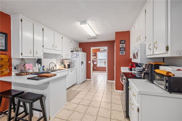 kitchen with white appliances, light countertops, a peninsula, and a sink