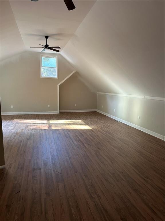 additional living space with ceiling fan, vaulted ceiling, and dark wood-type flooring