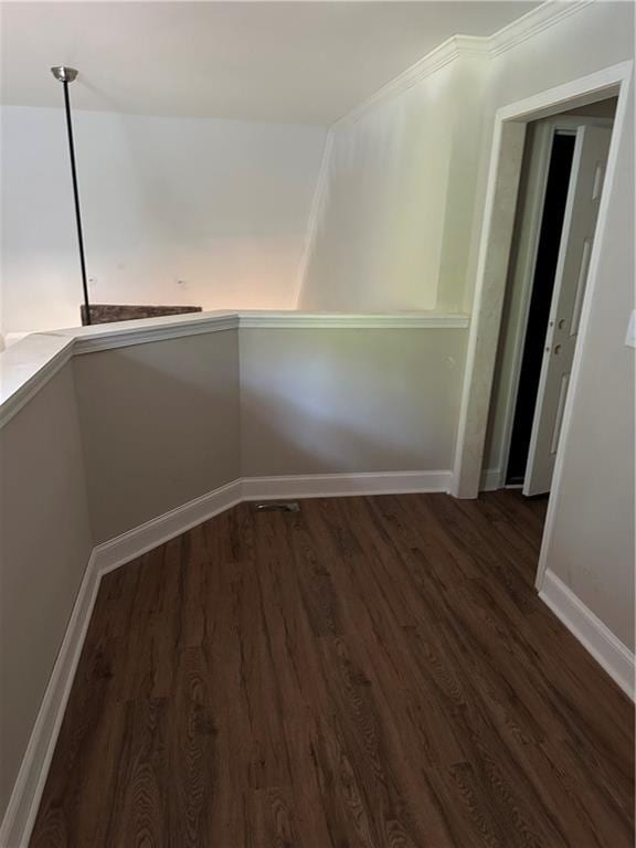 corridor with dark hardwood / wood-style floors and ornamental molding