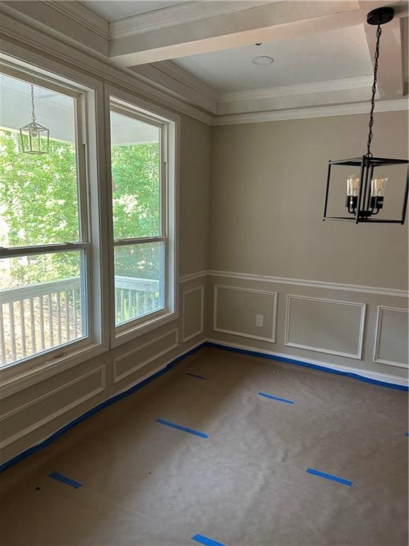 spare room featuring crown molding and an inviting chandelier