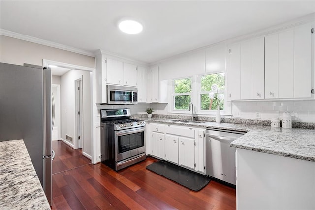 4497 Windsor Oaks Dr, Marietta, GA 30066 - kitchen featuring appliances with stainless steel finishes, ornamental molding, decorative backsplash, dark wood-style flooring, and white cabinetry