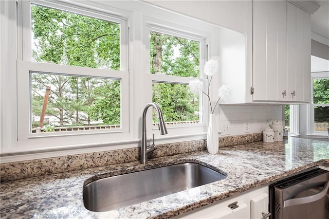 4497 Windsor Oaks Dr, Marietta, GA 30066 - kitchen featuring white cabinetry, light stone counters, healthy amount of natural light, and tasteful backsplash