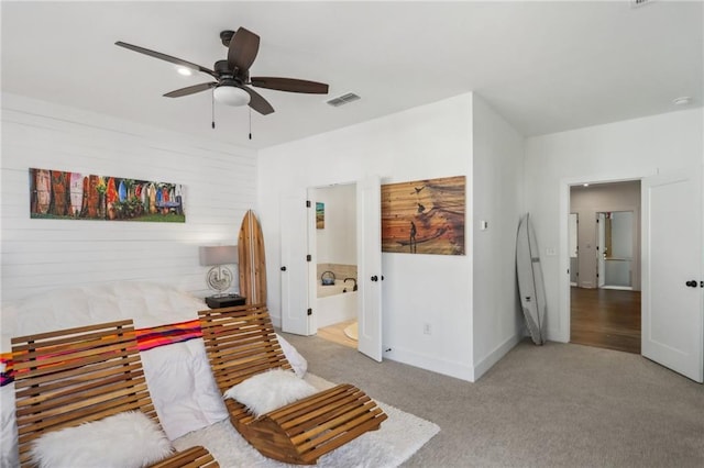 carpeted bedroom with visible vents, baseboards, ceiling fan, and ensuite bathroom