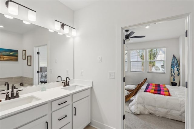 ensuite bathroom featuring connected bathroom, a ceiling fan, and a sink