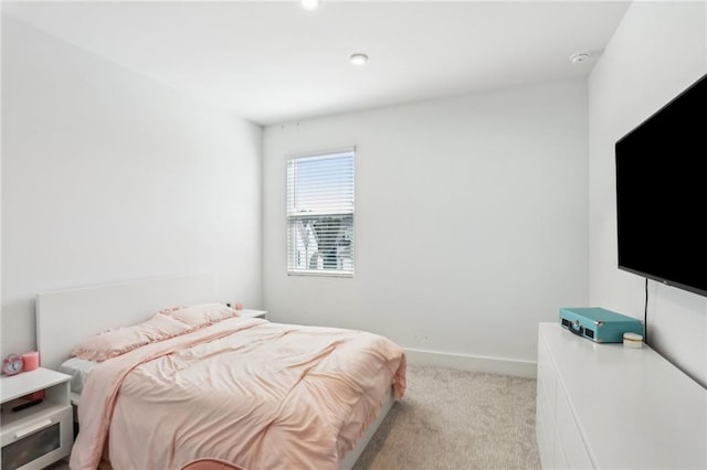 bedroom featuring light colored carpet and baseboards