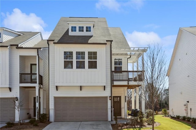 townhome / multi-family property featuring driveway, a pergola, board and batten siding, a garage, and a balcony