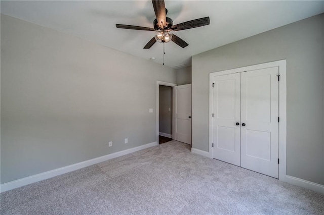 unfurnished bedroom featuring ceiling fan, a closet, and light carpet