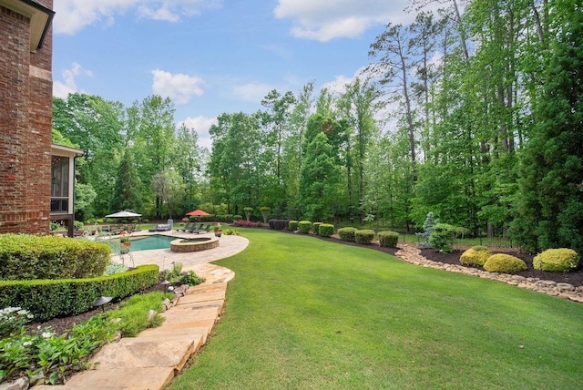 view of yard with a patio area and a pool with connected hot tub