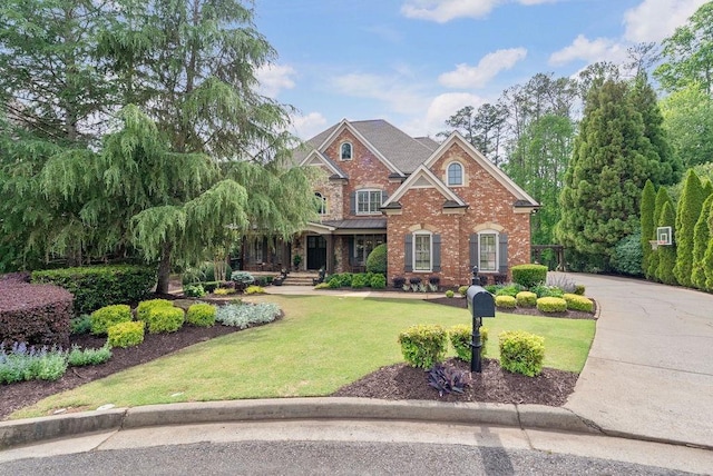 view of front facade with a front lawn and brick siding