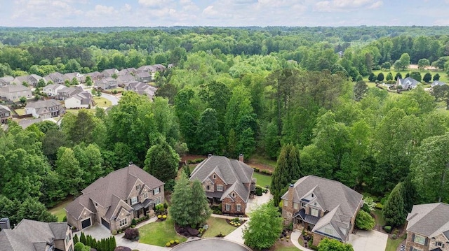 bird's eye view featuring a wooded view and a residential view