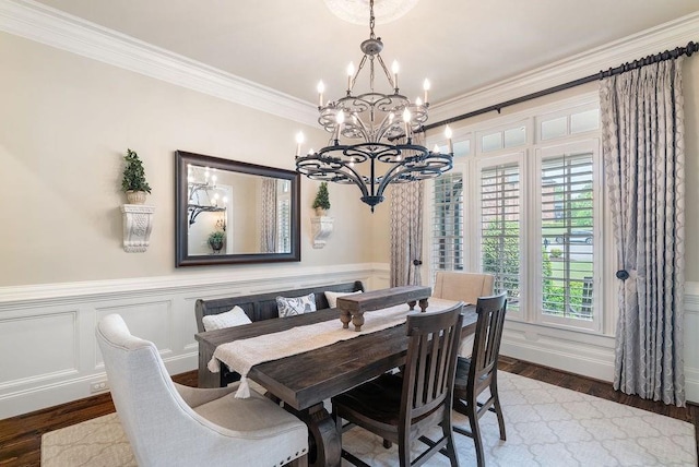 dining room with an inviting chandelier, ornamental molding, wainscoting, and wood finished floors