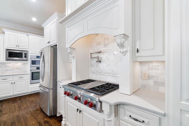 kitchen with light countertops, white cabinetry, appliances with stainless steel finishes, and decorative backsplash