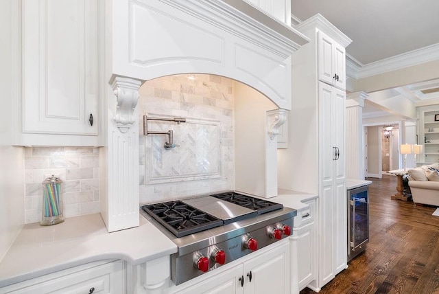 kitchen featuring crown molding, stainless steel gas cooktop, light countertops, white cabinets, and wine cooler
