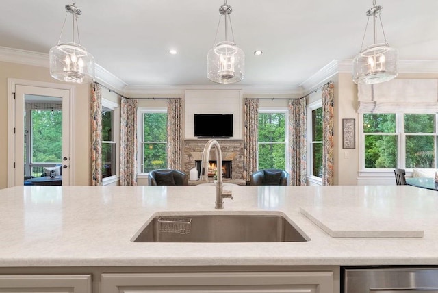 kitchen featuring a lit fireplace, dishwasher, a sink, light countertops, and open floor plan