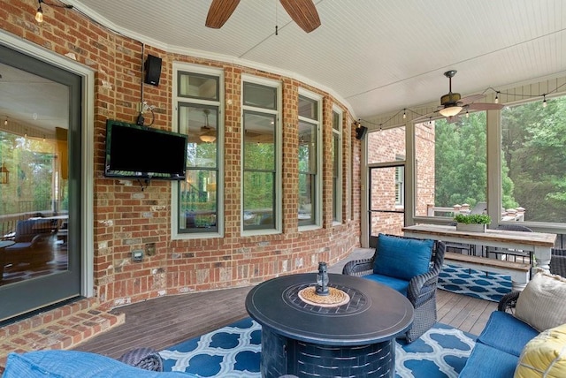 sunroom / solarium featuring a ceiling fan