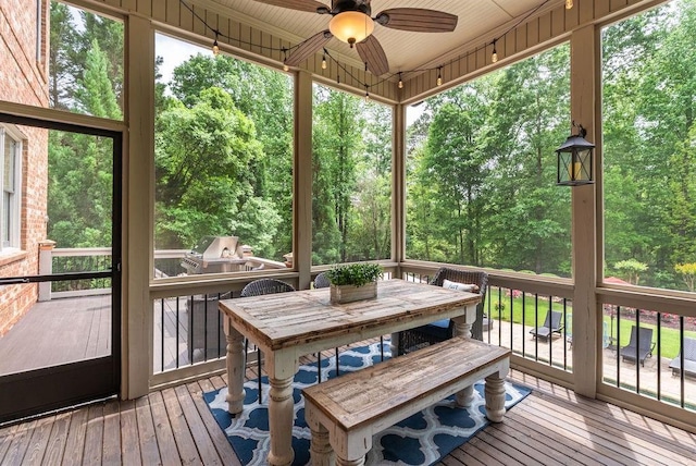 sunroom / solarium with ceiling fan and outdoor dining area