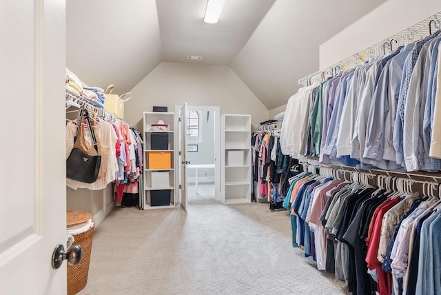 spacious closet featuring carpet floors, visible vents, and lofted ceiling