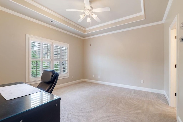 unfurnished office featuring crown molding, ceiling fan, light colored carpet, and a raised ceiling