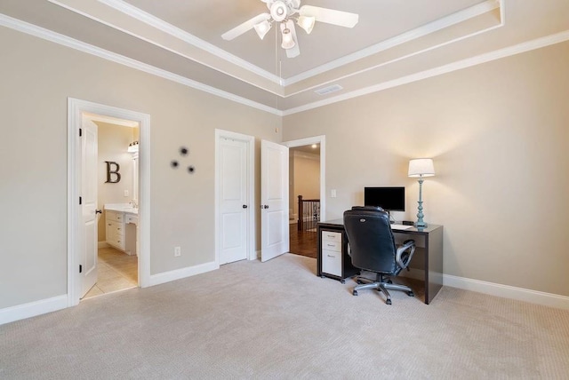 carpeted office space with crown molding, a raised ceiling, ceiling fan, and baseboards