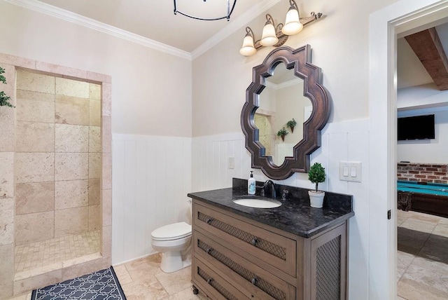 bathroom featuring a decorative wall, toilet, ornamental molding, and a wainscoted wall