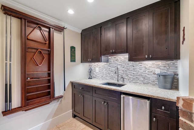 kitchen featuring a sink, ornamental molding, fridge, and tasteful backsplash