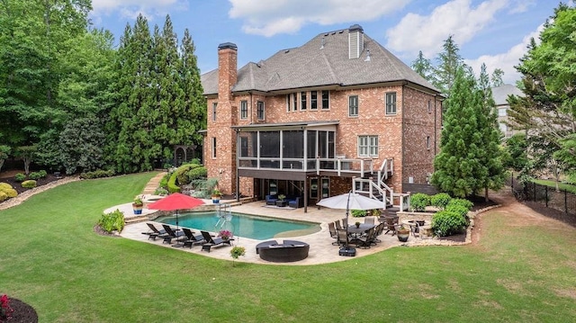 back of property with a chimney, a sunroom, a patio area, fence, and a yard