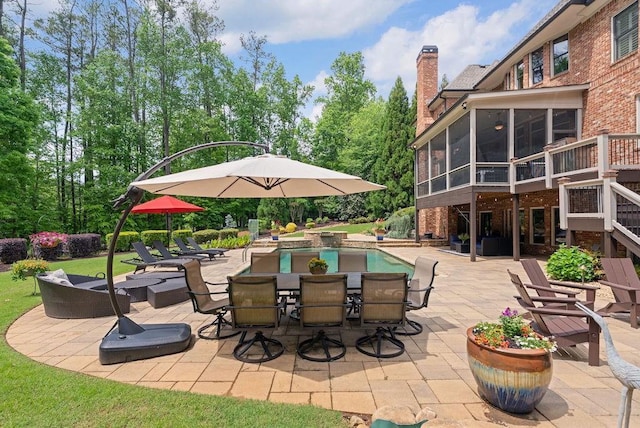view of patio featuring an outdoor pool, a sunroom, and stairs